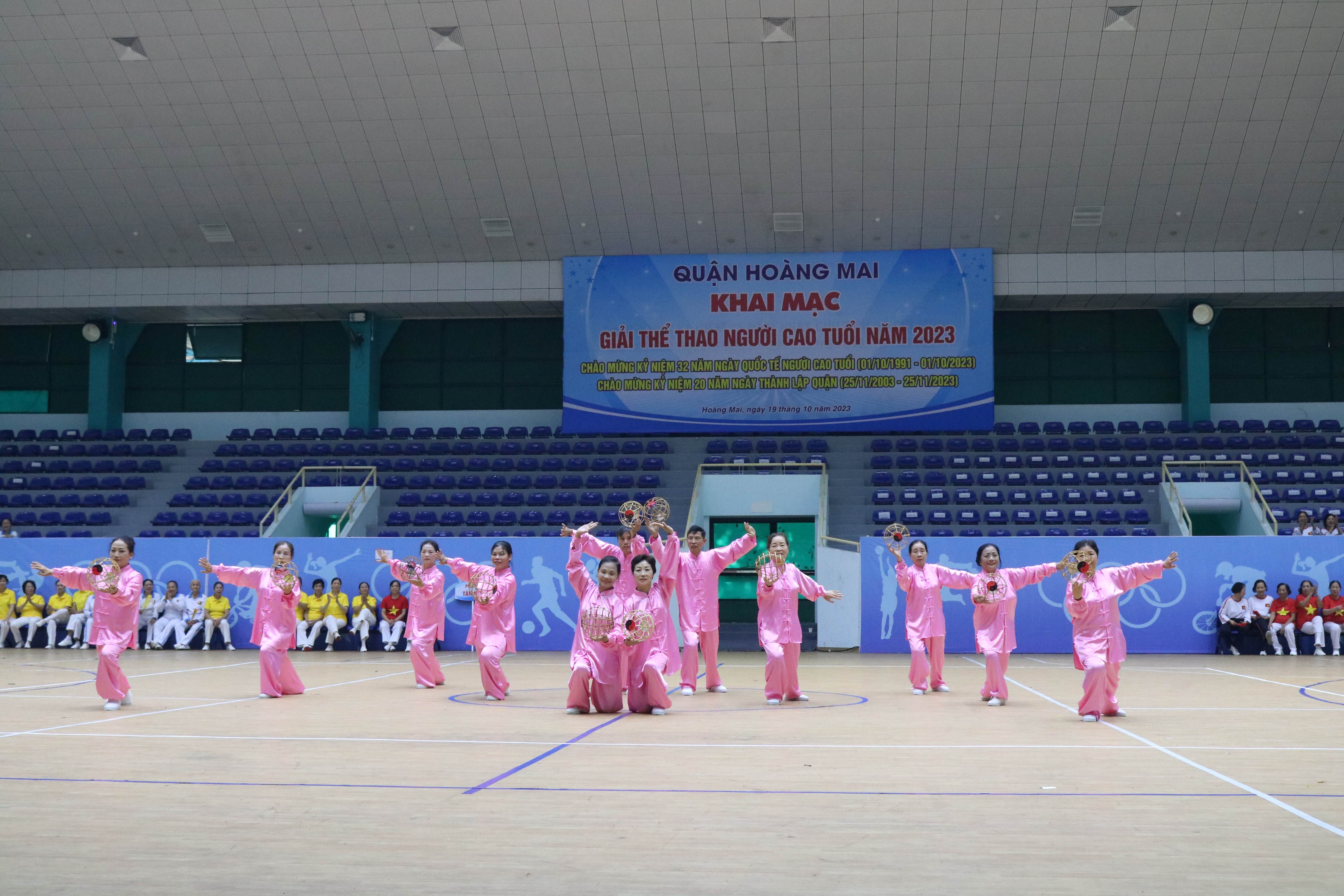 A group of people in pink outfits performing martial artsDescription automatically generated